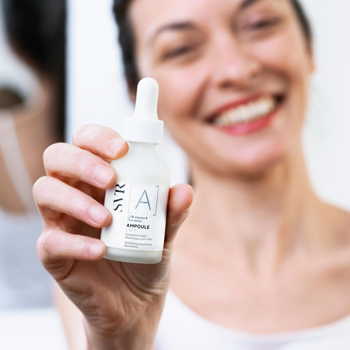 Svr A Ampoule Lift 30ml en las manos de una mujer sonriendo, ideal para una piel suave y rejuvenecida.